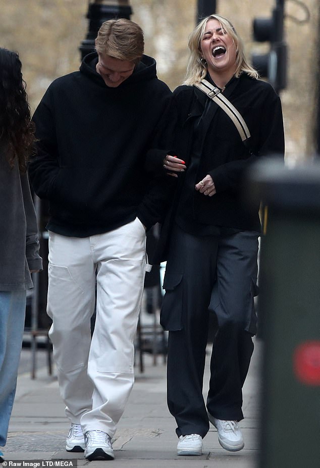 Laughs: The footballer, 24, and the performer, 26, looked loved-up as they enjoyed a giddy stroll in Mayfair after enjoying lunch at Japanese restaurant Roka