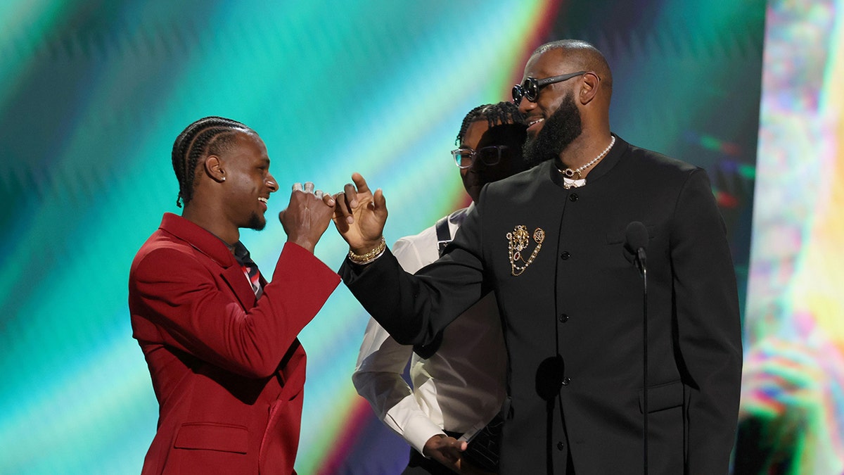 Bronny James and LeBron James handshake on stage