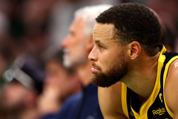 Stephen Curry of the Golden State Warriors looks on from the bench during the first quarter against the Boston Celtics at TD Garden on March 03, 2024...