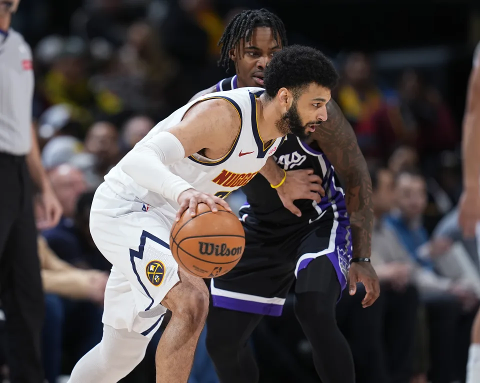 Denver Nuggets guard Jamal Murray, front, drives past Sacramento Kings guard Davion Mitchell during the first half of an NBA basketball game Wednesday, Feb. 28, 2024, in Denver. (AP Photo/David Zalubowski)