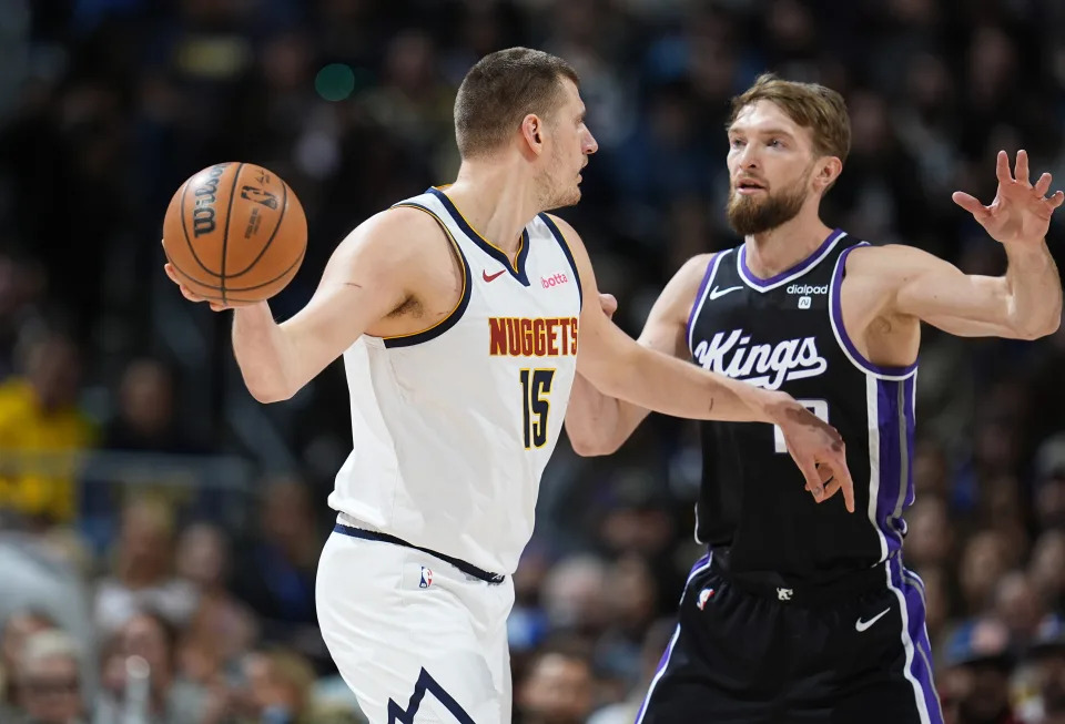 Denver Nuggets center Nikola Jokic, left, looks to pass the ball as Sacramento Kings forward Domantas Sabonis defends during the first half of an NBA basketball game Wednesday, Feb. 28, 2024, in Denver. (AP Photo/David Zalubowski)