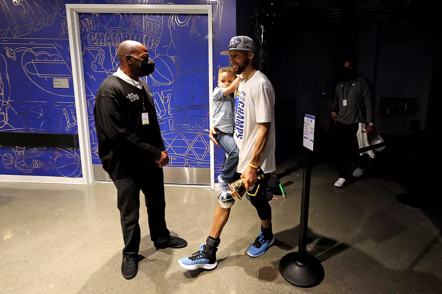 Stephen Curry #30 of the Golden State Warriors walks off the court with son Canon and the Magic Johnson Western Conference Finals MVP award after a 120-110 win against the Dallas Mavericks in Game Five of the 2022 NBA Playoffs Western Conference Finals at Chase Center on May 26, 2022 in San Francisco, California.