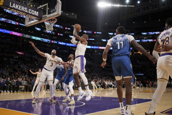 Los Angeles Lakers forward LeBron James, center, goes to the basket during the first half of an NBA basketball game against the Minnesota Timberwolves in Los Angeles, Sunday, March 10, 2024. (AP Photo/Eric Thayer)