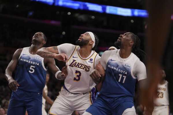 Minnesota Timberwolves guard Anthony Edwards (5), Los Angeles Lakers forward Anthony Davis (3) and Timberwolves center Naz Reid (11) wait for a rebound during the first half of an NBA basketball game in Los Angeles, Sunday, March 10, 2024. (AP Photo/Eric Thayer)