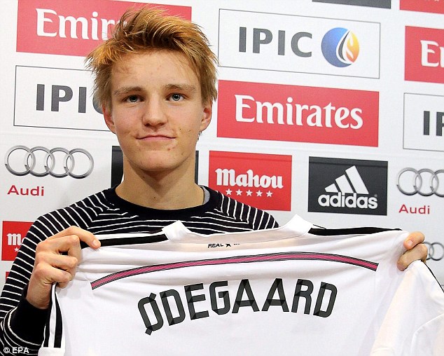 Odegaard holds his shirt after being unveiled as a Real Madrid player, where he will be paid £40,000 a week