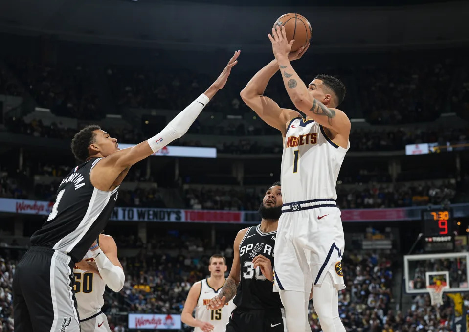 Denver Nuggets forward Michael Porter Jr., right, shoots over San Antonio Spurs center Victor Wembanyama during the first half of an NBA basketball game Tuesday, April 2, 2024, in Denver. (AP Photo/David Zalubowski)