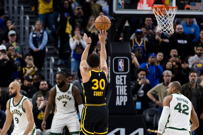 Golden State Warriors guard Steph Curry attempts a three-point shot against the Boston Celtics during their game on Dec. 19, 2023.