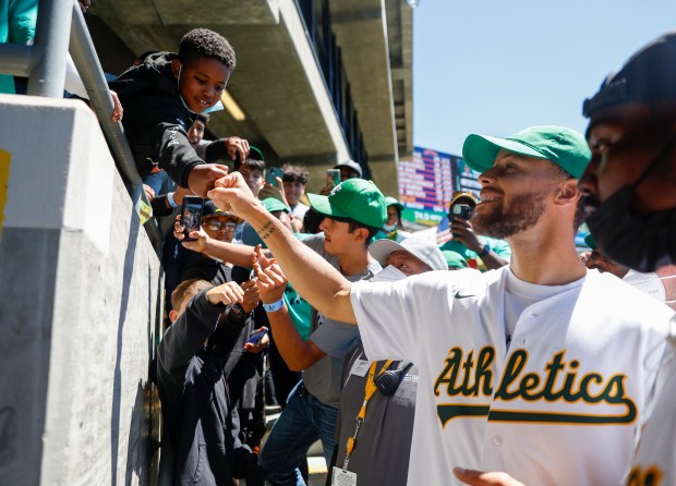 OAKLAND, CALIFORNIA - JULY 27: A young fan fist-bumps Golden...