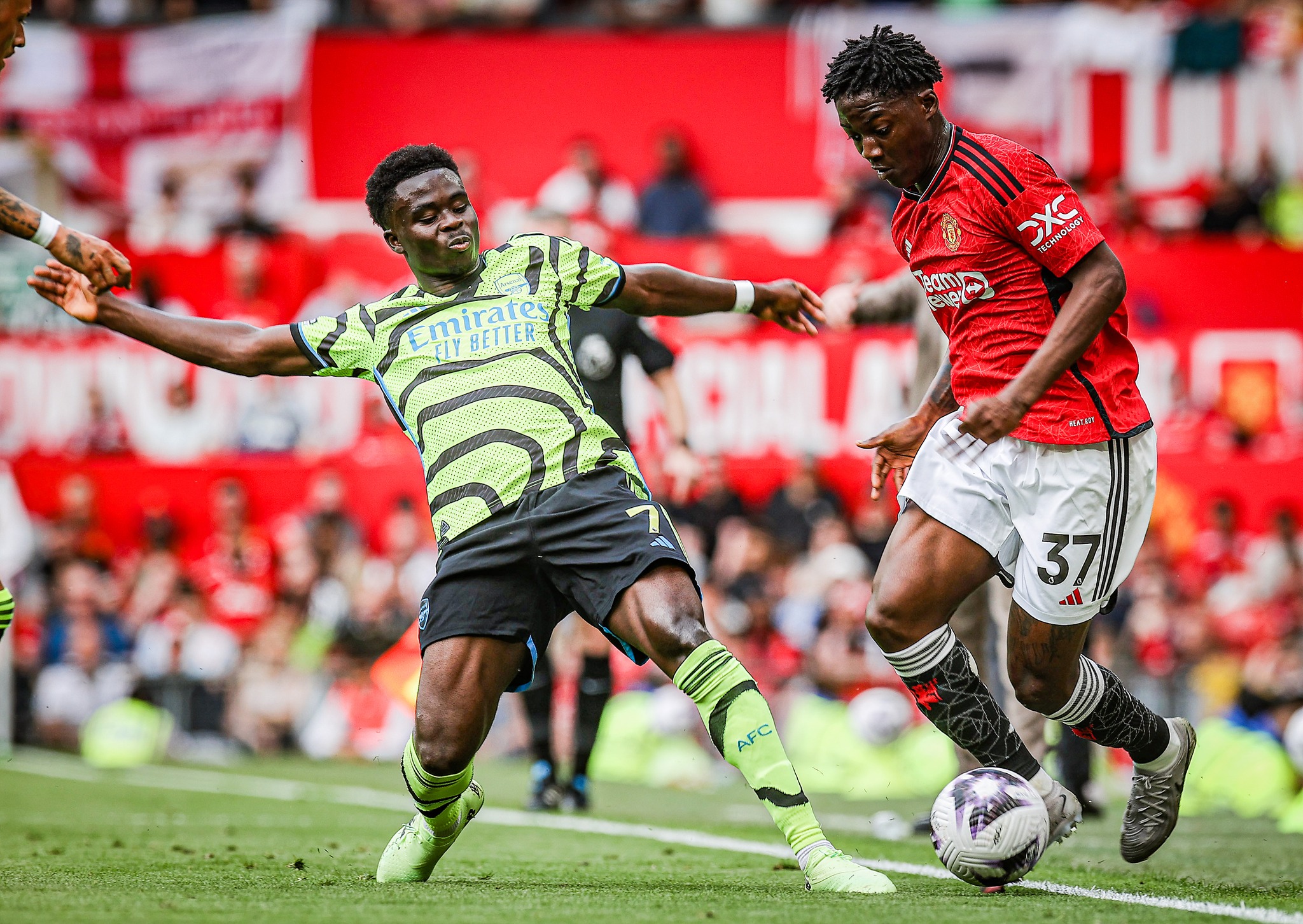 Bukayo Saka tries to tackle Kobbie Mainoo.