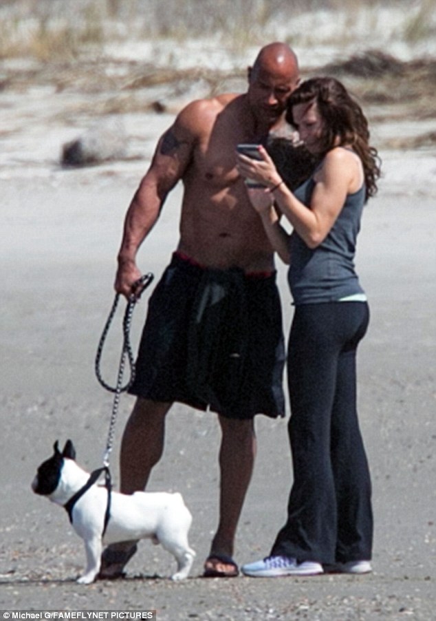 Check it out: The Rock studied the photos on Lauren's camera phone while Hobbs stood watch nearby