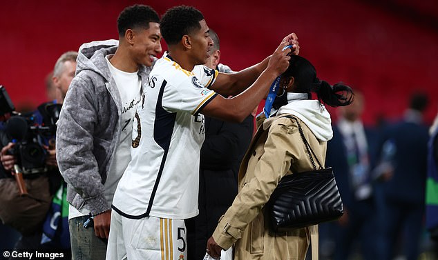 Jude Bellingham wraps his Champions League final medal around his mother's neck while brother Jobe beams