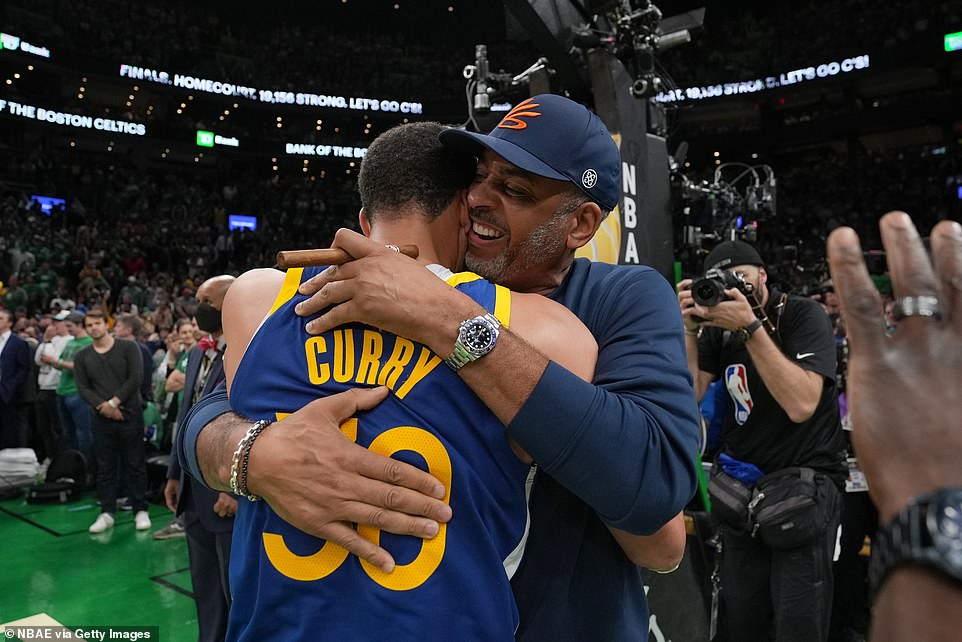 Stephen and Dell (right) Curry embrace each other after the former's fourth NBA title