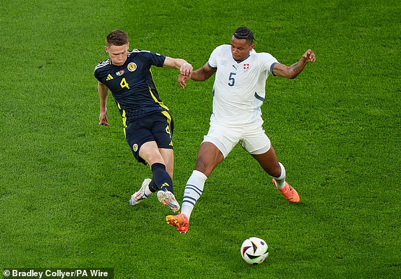 Scotland's Scott McTominay (left) and Switzerland's Manuel Akanji battle for the ball during the UEFA Euro 2024 Group A match at the Cologne Stadium in Cologne, Germany. Picture date: Wednesday June 19, 2024. PA Photo. See PA Story SOCCER Scotland. Photo credit should read: Bradley Collyer/PA Wire.RESTRICTIONS: Use subject to restrictions. Editorial use only, no commercial use without prior consent from rights holder.