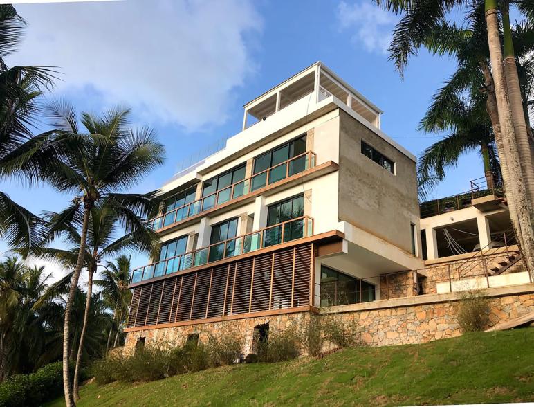 The gated, guarded four-story home is made of natural materials including wood, stones, rusted steel, brut concrete and coral stone, according to the listing.