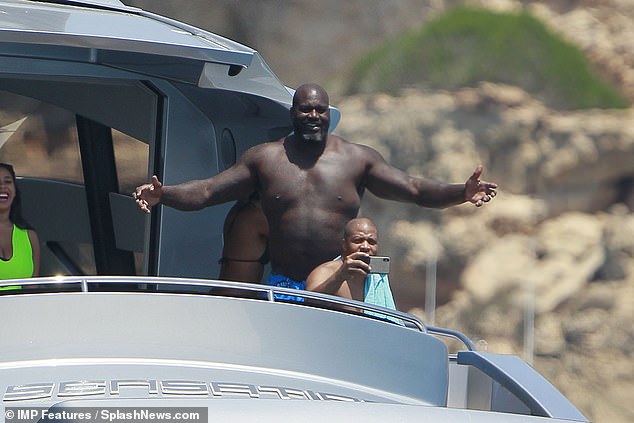 Waving it up: The star smiled as he took in the stunning view of himself on the yacht