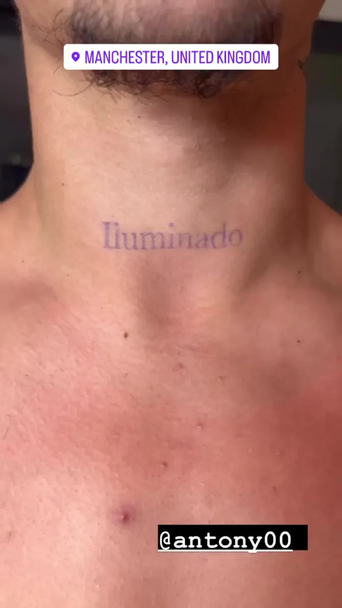 His neck tattoo reads 'illuminado' or 'illuminated' in English