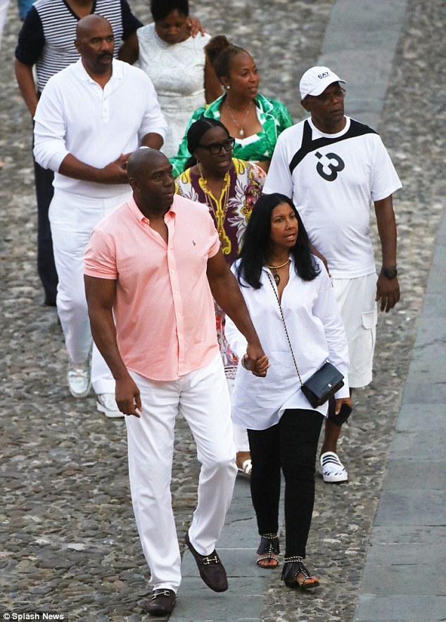 On their way: Magic, 56, took the lead holding Cookie's hand while the others followed along behind on the picturesque harbour's cobblestone streets